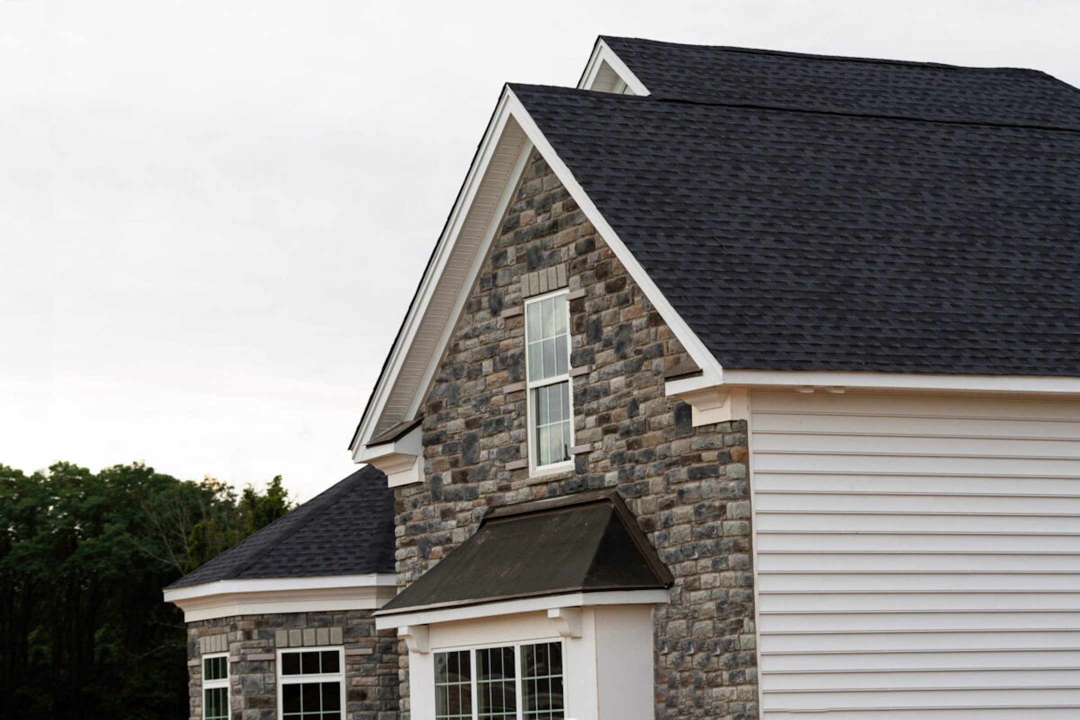 edge of roof shingles on top of the house dark asphalt tiles on the roof background color