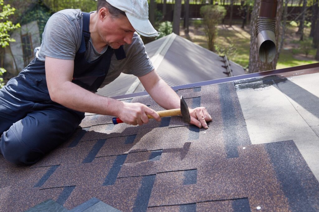 The master on the roof installs flexible tiles. Construction of houses.