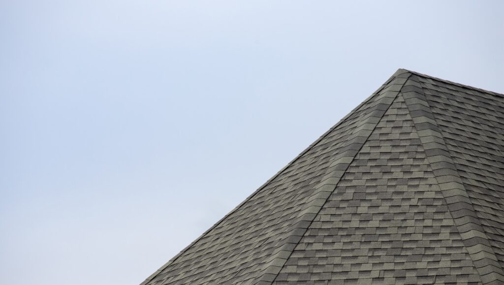 roof shingle background and texture. edge of rubber tile against blue sky.