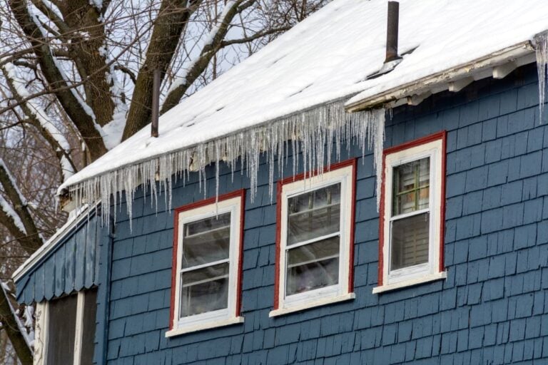 Snow-covered roof with long icicles