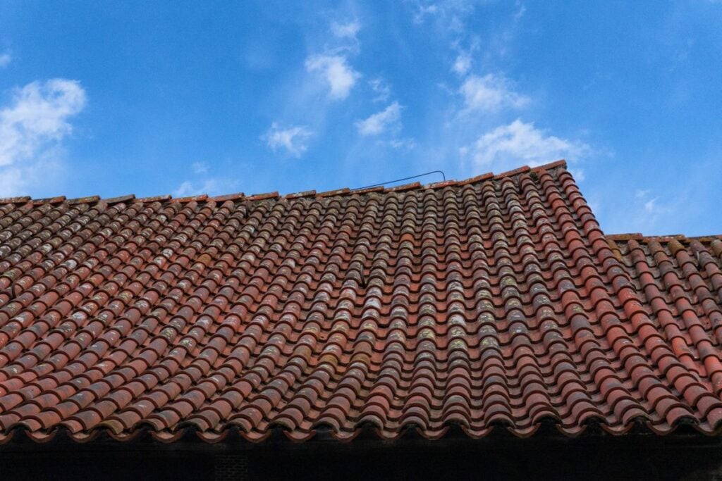 aged terracotta roof tiles on a sagging gable