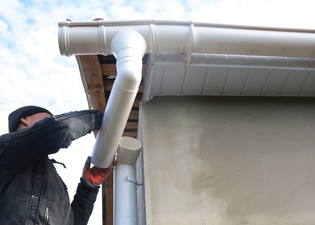gutter downspout repair worker fixing water system