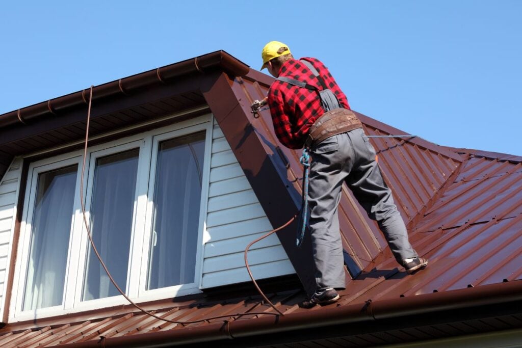 standing seam vs corrugated metal roof worker installing metallic roof