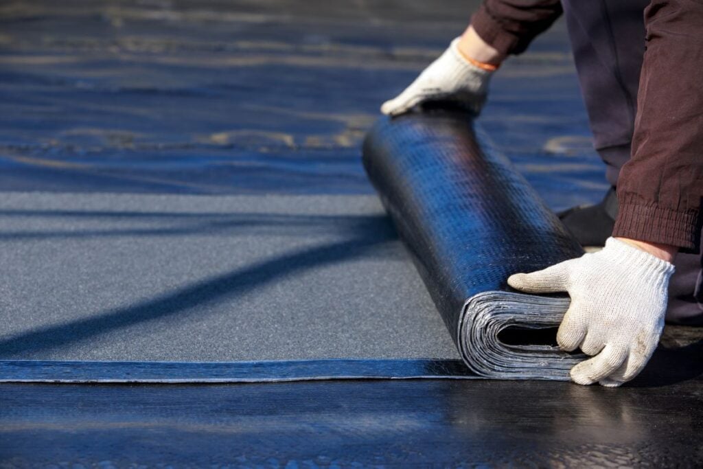 modified bitumen roofing system worker installing new membrane