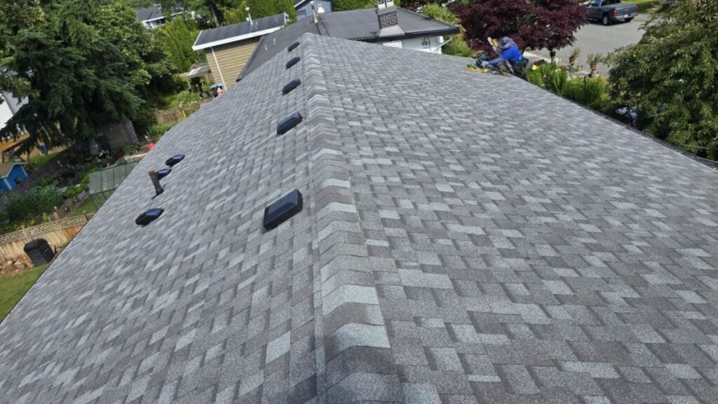 asphalt shingle roof replacement worker on top of shingles roof