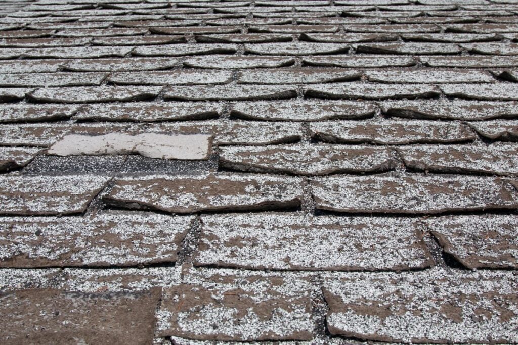curling shingles white and brown old roof