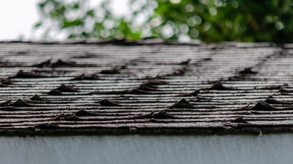 curling shingles brown deteriorated old house