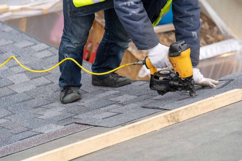 most durable roofing material worker using nail gun to replace bad shingles