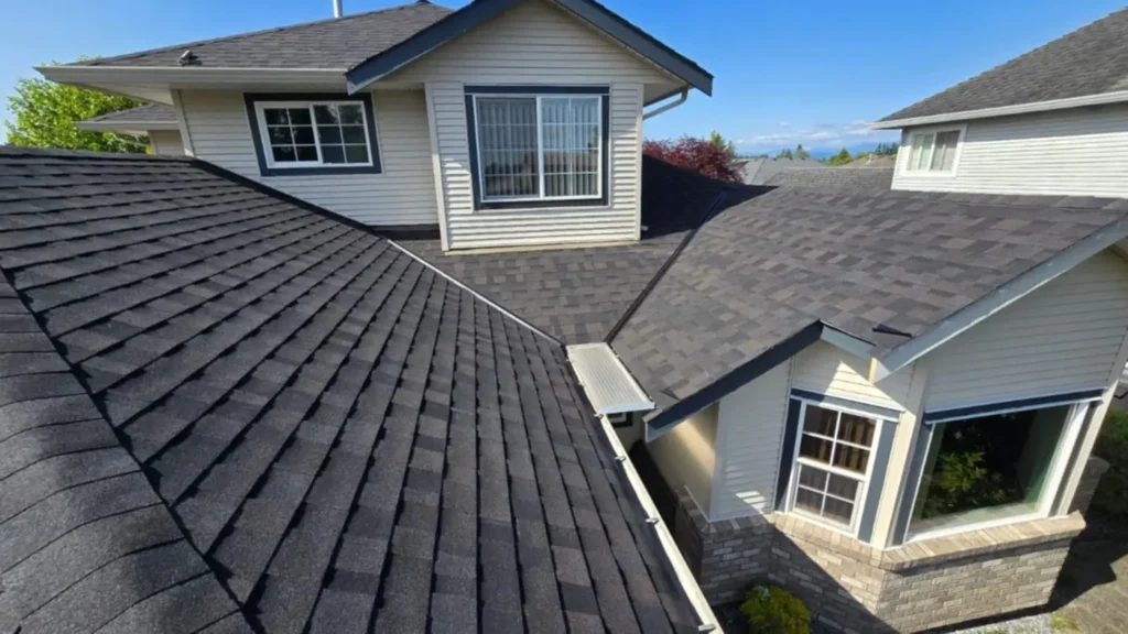 close up view of roof ridge on new roof replacement, grey asphalt shingles